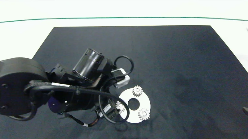 Dual robot grippers assembling small planetary gears on a carrier in the RoCo Challenge.